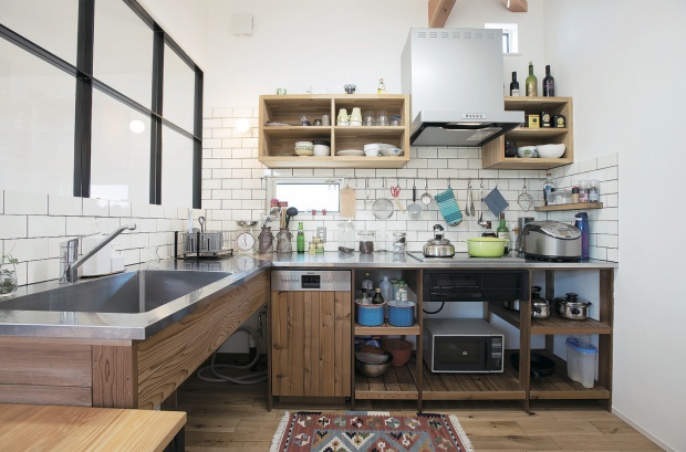 レトロ感漂う個性的なキッチン。壁に取り付けられたハンガーレールが調理器具をインテリアのように演出します。